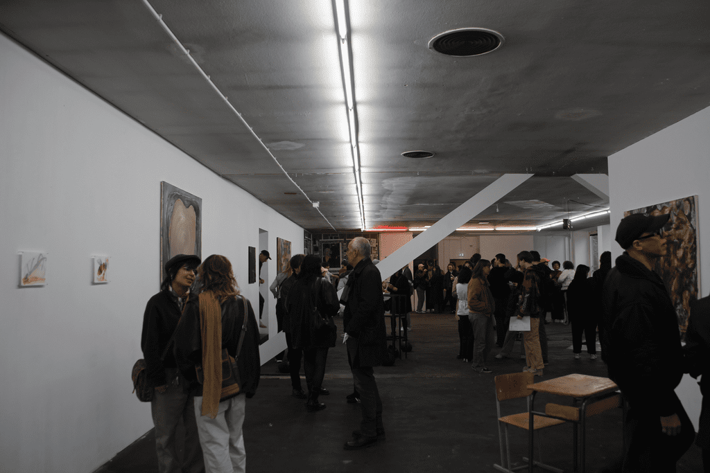 Blick in die Ausstellung, der Raum ist gefüllt mit Personen.