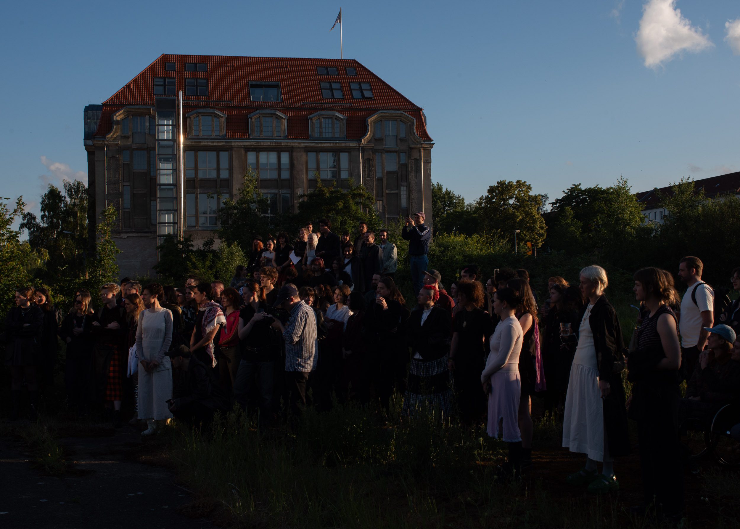 Eine Gruppe Menschen steht im Garten, im Hintergrund steht die Villa Heike.