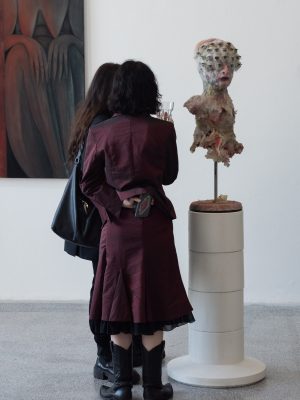 Zwei Personen stehen vor einer Skulptur.